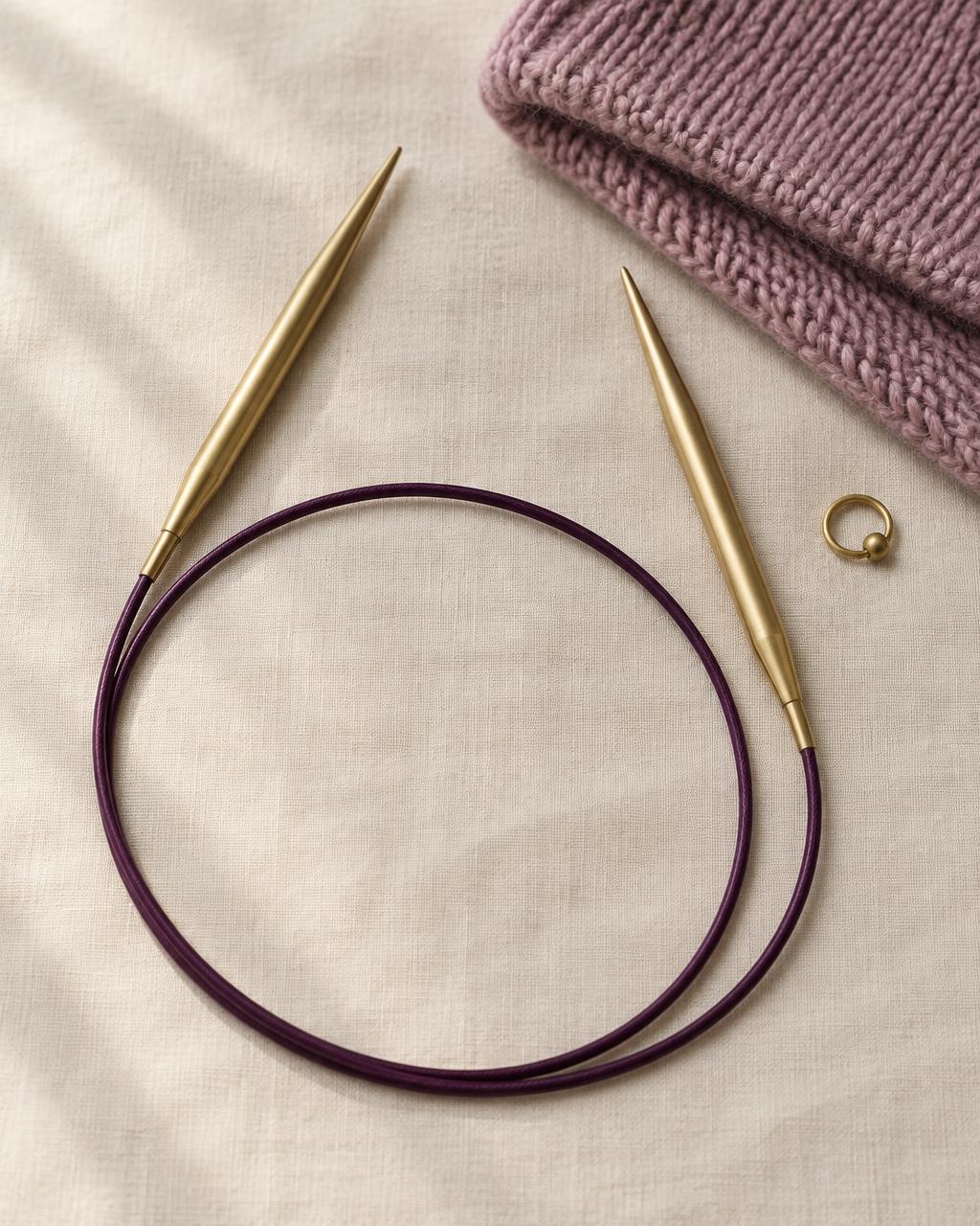 Aura brushed brass fixed circular needles with a plum cable
